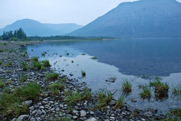 Il lago della sera nella nebbia blu