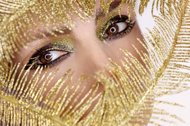 Evening party eye makeup close-up with Golden shiny jewelry.