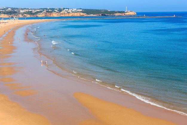 Evening sandy beach Praia dos Tres Castelos, Portimao, Algarve, Portugal. Top view, people are unrecognizable.