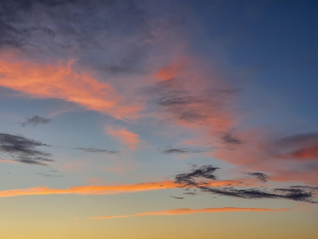 カラフルな夕日と雄大な太陽の光で素晴らしい夕方の空夕暮れ紫ピンクと青の自然夕暮れの空の背景夕焼け空に巻雲の雲の抽象的なパターン大気現象