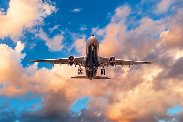 Evening sky with broken beautiful clouds of warm colors and airplane takes off from the airport.