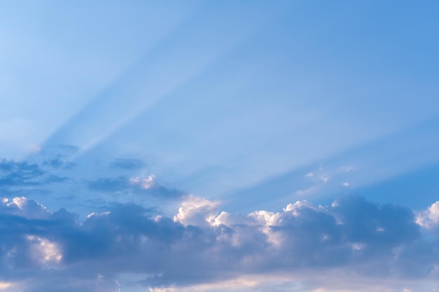 夕方の空と雲の驚くほどカラフルな夕焼けと雄大な日差しが黄昏の紫色のピンク色を背景に