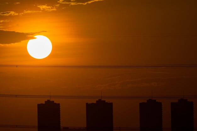 都市に夕日とシルエットのある夜の空