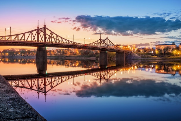 Photo evening at starovolzhsky bridge in tver with reflection in the waters of the volga river