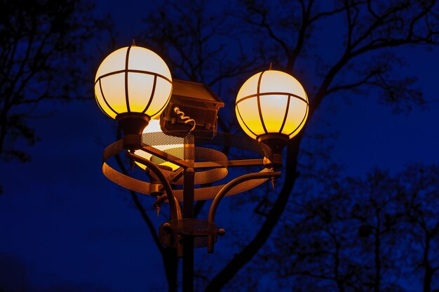 Evening street lamp with round shades against a dark blue sky background Warm on cold