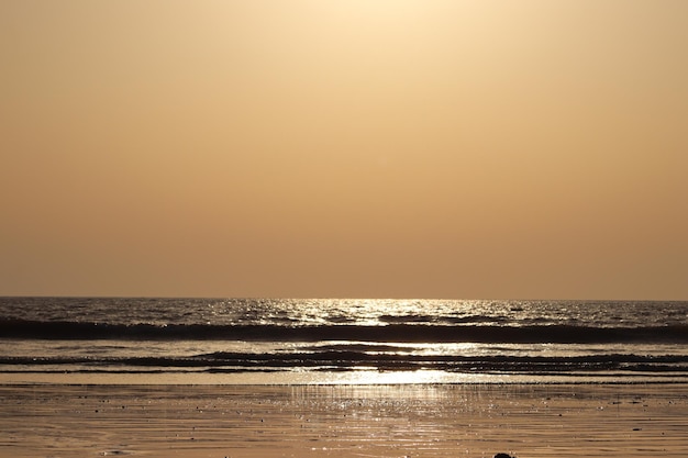 Photo evening sunset view on the beach with ocean waves