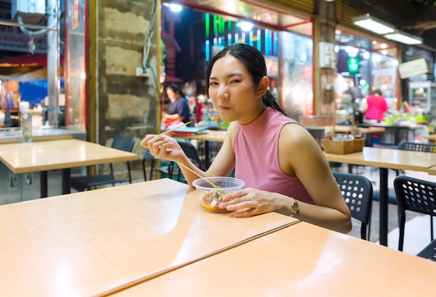 In the evening, Thai-Chinese tourists stroll around and sample street food at Yaowarat Road, Chinatown, Bangkok and sample delicious street food. There are seafood, dessert, pad Thai, noodles