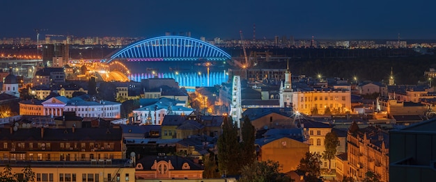 Evening view of the Podilskyi Bridge the Dnieper River and the Ferris Wheel