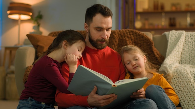 evening weekend home caucasian family parent father read book little kids girls children night sleep
