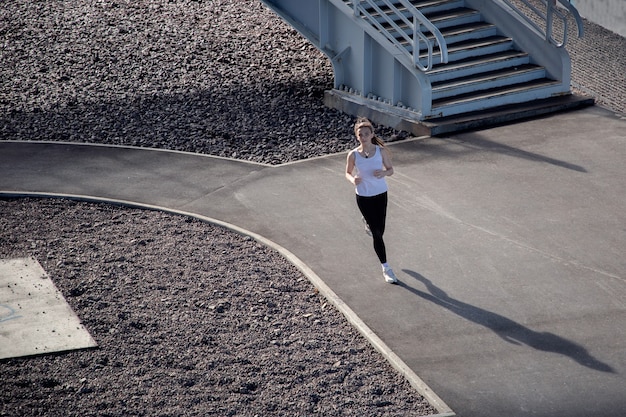 Evening young girl training on a treadmill