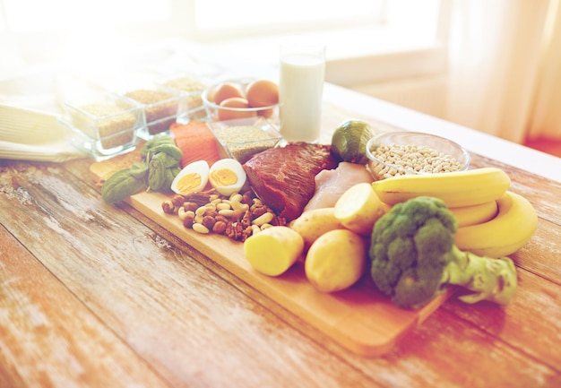 evenwichtig dieet, koken, culinair en voedselconcept - close-up van groenten, fruit en vlees op een houten tafel