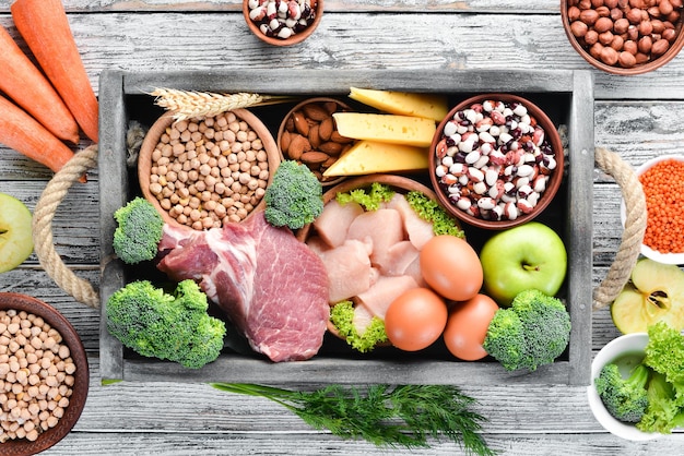 Evenwichtige voeding voedsel achtergrond vlees kipfilet broccoli bonen kaas eieren tarwe op een witte houten achtergrond