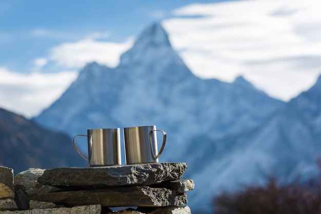 Everest base camp-trektocht. twee kopjes thee op de achtergrond van mount ama dablam in focus. bergen achtergrond wazig.