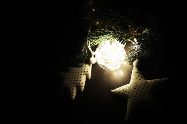 Фото Вечнозеленые елочные игрушки ручной работы, снежинки, глобусы и еловая ветка на каменном фоне, рождественская открытка с пространством для текста