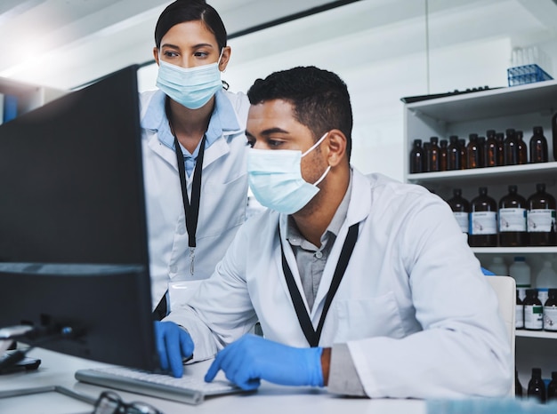 Every contribution brings us closer to our goal Shot of two young researchers using a computer in a laboratory