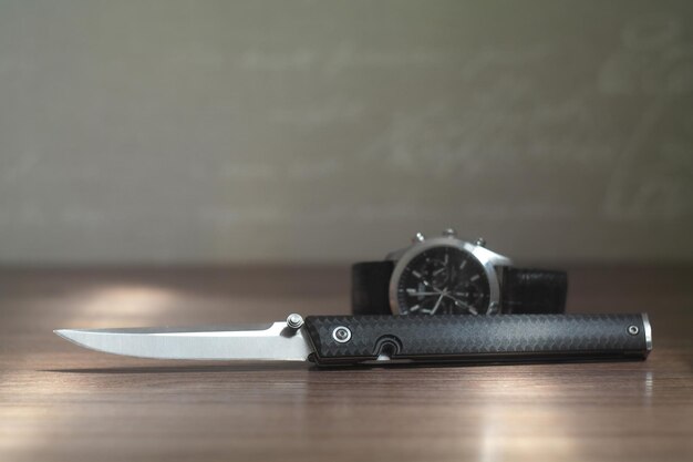 Everyday carry folder knife and wathes on table