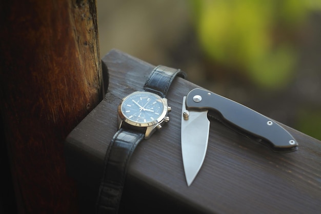Everyday carry knife and watches on handrail
