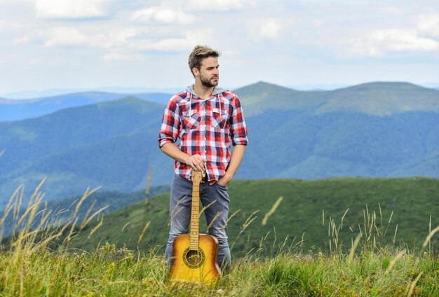 everyone deserve music sexy man with guitar in checkered shirt hipster fashion western camping and hiking happy and free cowboy man with acoustic guitar player country music song