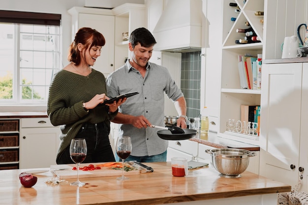 Everything has to look perfect for our blog Shot of a couple using a digital tablet while cooking at home