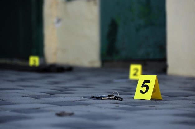 Evidence with yellow CSI marker for evidence numbering on the residental backyard in evening Crime scene investigation concept