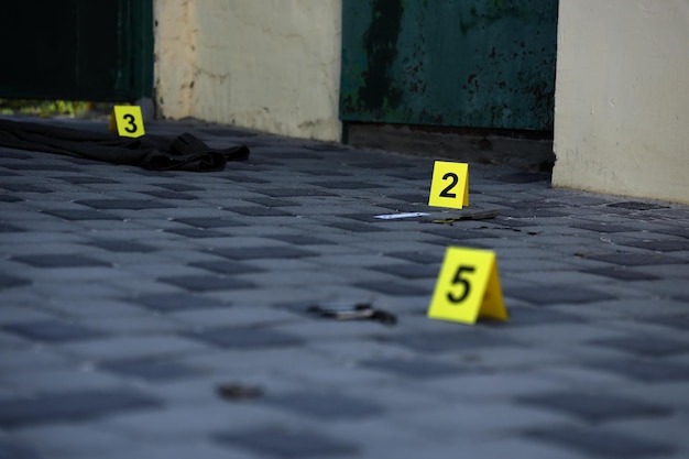 Улики с желтым маркером CSI для нумерации улик на заднем дворе жилого дома в вечернее время Концепция расследования места преступления