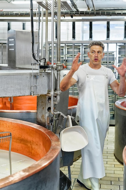 Evillers, france - august 31, 2016: cheese maker processes\
gruyere de comte cheese in the dairy in franche comte, burgundy,\
france.