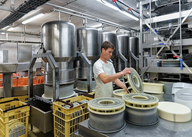 Evillers, France - August 31, 2016: Cheese maker putting Gruyere de Comte Cheese into the forms at the dairy in Franche Comte, Burgundy, in France.