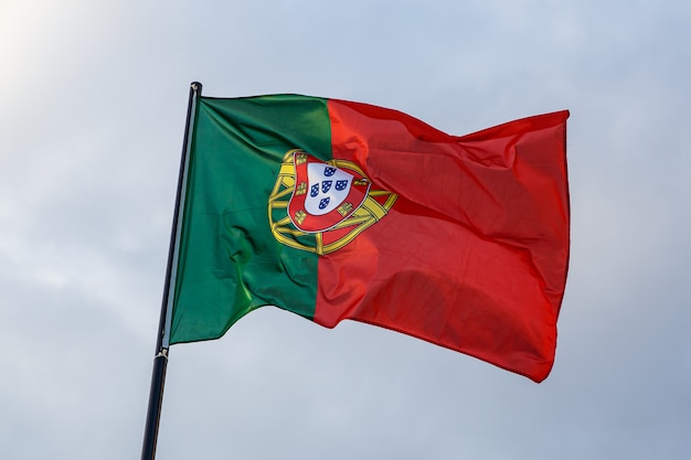 Evoluerende Portugese vlag, wolken op blauwe hemel