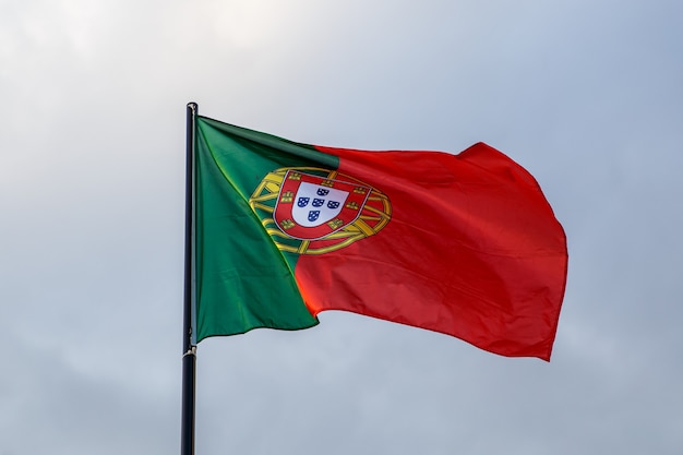 Evoluerende Portugese vlag, wolken op blauwe hemel