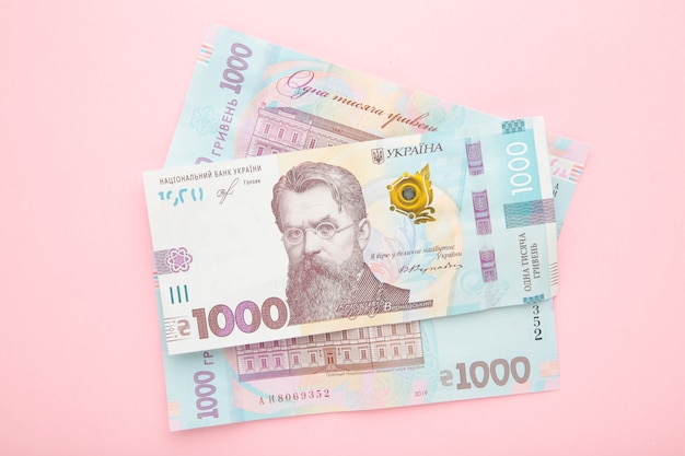 Тew banknote of Ukraine on pink surface