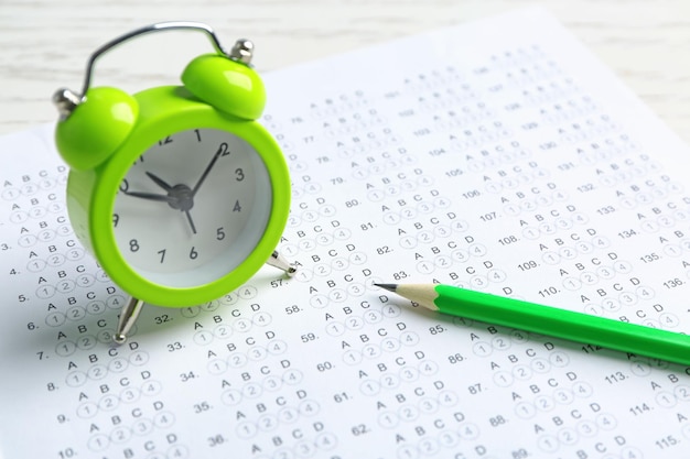 Photo exam form pencil and alarm clock on table