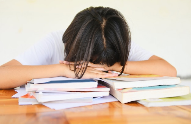 Экзамен по стрессу образования молодой женщины колледжа в классе заметок, сидя, обучение подчеркнул студент