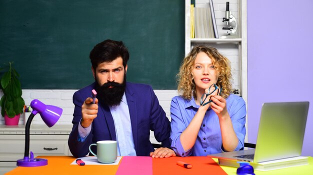 Examen op de universiteit jonge mannelijke leraar met vrouwelijke student over groene schoolbord achtergrond leraren