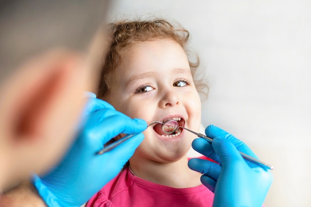 Foto esame, trattamento denti bambini. visita medica cavità orale con strumento. cure odontoiatriche