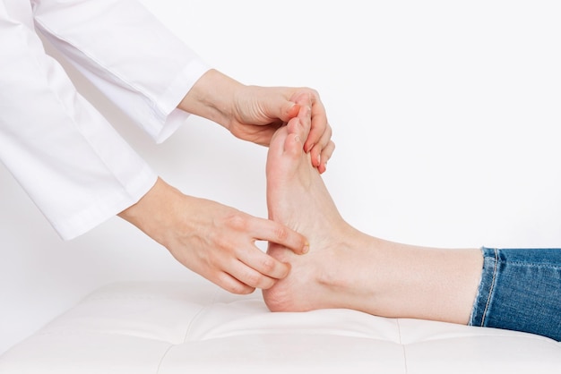 Examination of a young woman by an orthopedist Cropped shot of female doctor holding a girl's foot