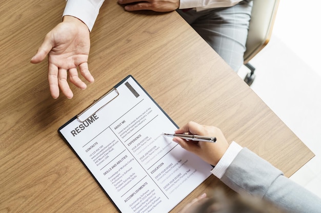 Photo examiner reading a resume during job interview at office business and human resources concept