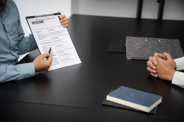 Examiner reading a resume during job interview at office Business and human resources concept