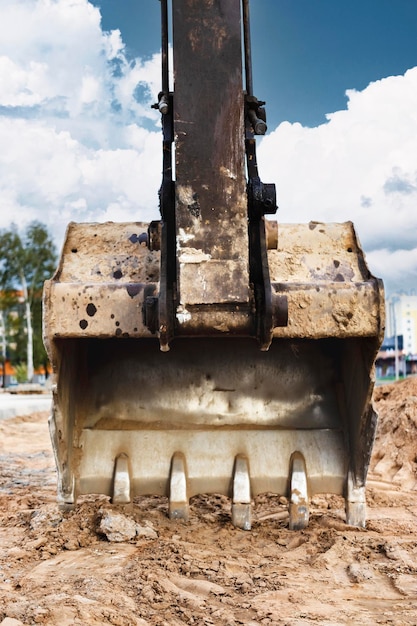 Foto primo piano della benna dell'escavatore lavori di scavo in cantiere e costruzione di strade macchine edili