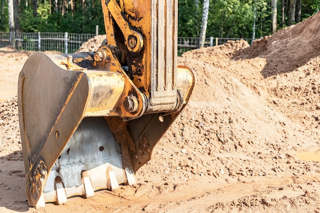 Foto benna dell'escavatore da vicino. lavori di scavo in cantiere e costruzione di strade. macchine da cantiere.