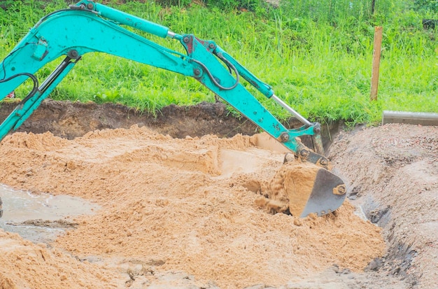 Excavator bucket digs sand