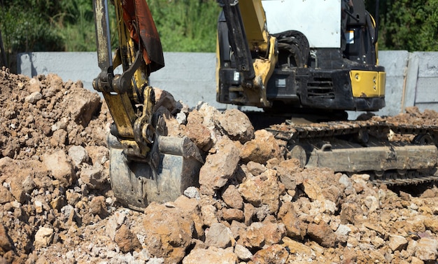 Excavator bulldozer in sandpit digging soil on construction site