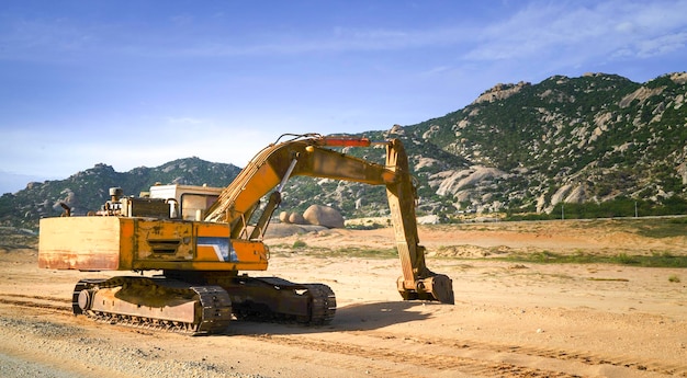 Excavator on a construction site next to a hill