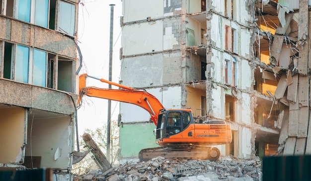 Экскаватор разрушает старое здание в городе