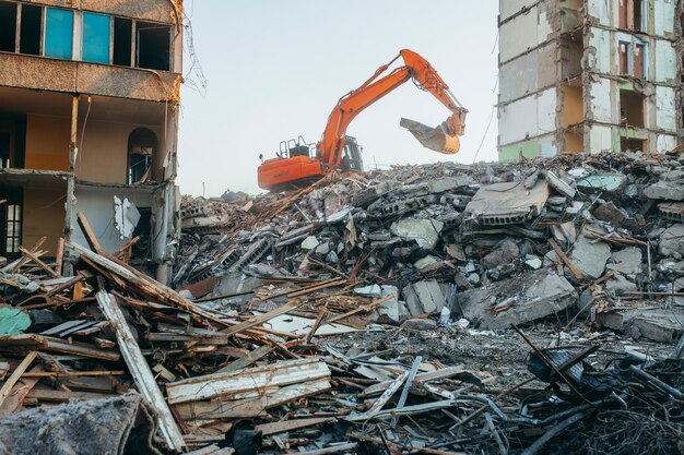 Excavator destroys an old building in the city