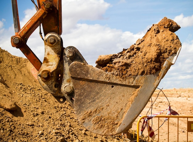 Excavator digging a deep trench, working, sand