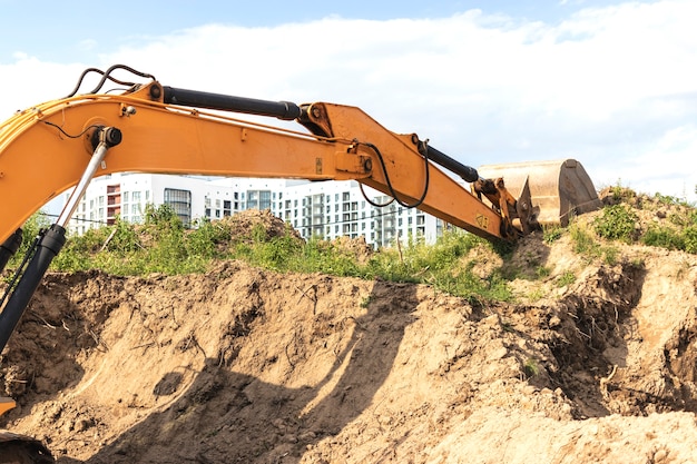 掘削機は、住宅の建設のための基礎ピットを掘ります。背景の新しい住宅。建設生産。発掘。