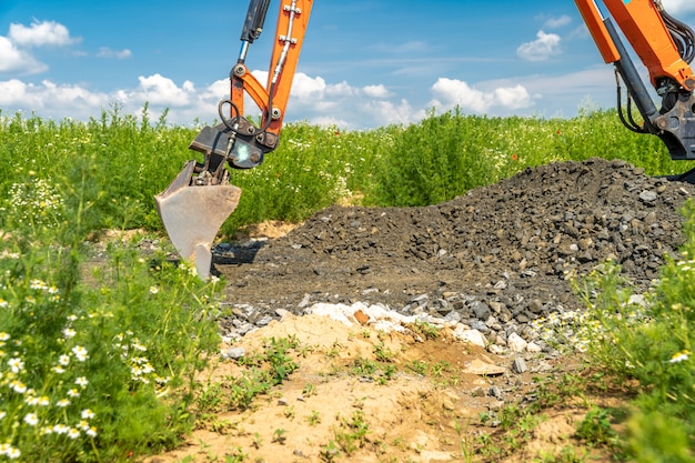 Foto l'escavatore scava ghiaia per la costruzione di strade