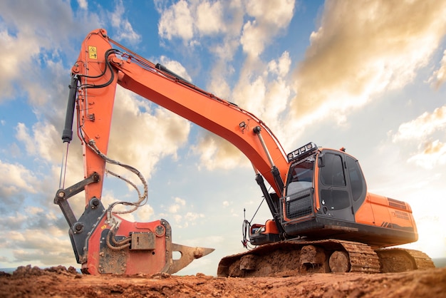 Excavator drilling on top of rocks at foundation infrastructure construction site 