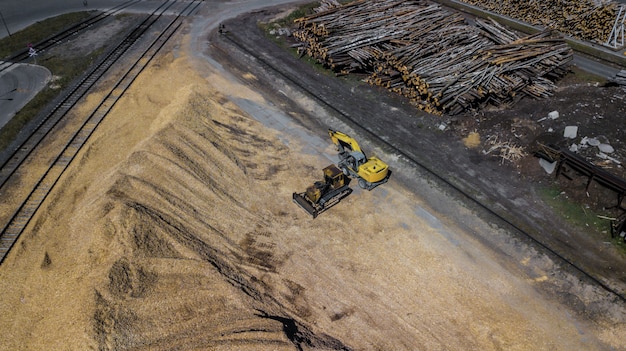 Excavator from a pile of sawdust . Woodworking industry.