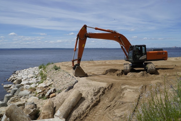 掘削機は、ロシアのウリヤノフスク川の砂浜を平らにします